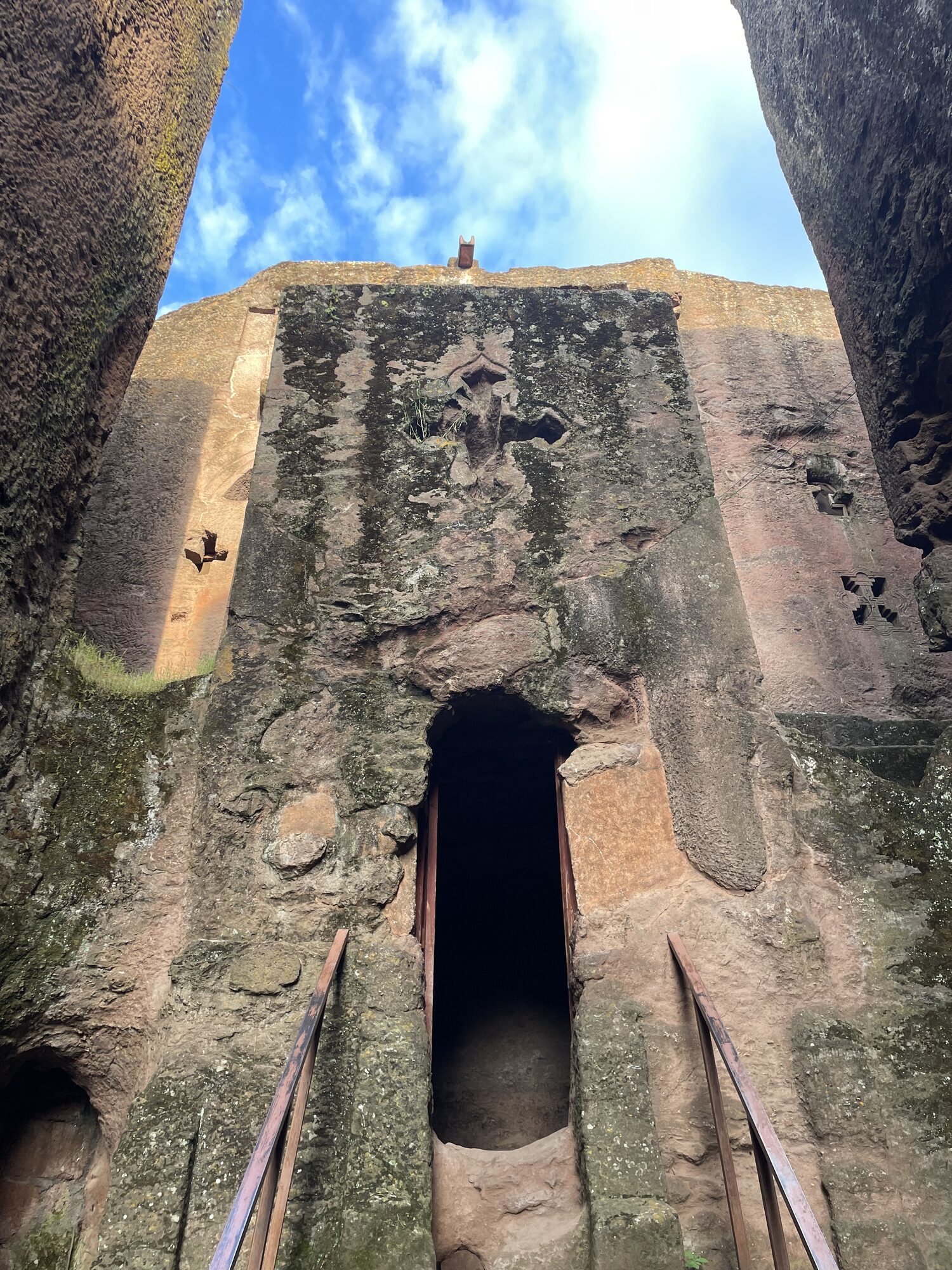 Looking up at the carved exterior walls of a Lalibela rock-hewn church