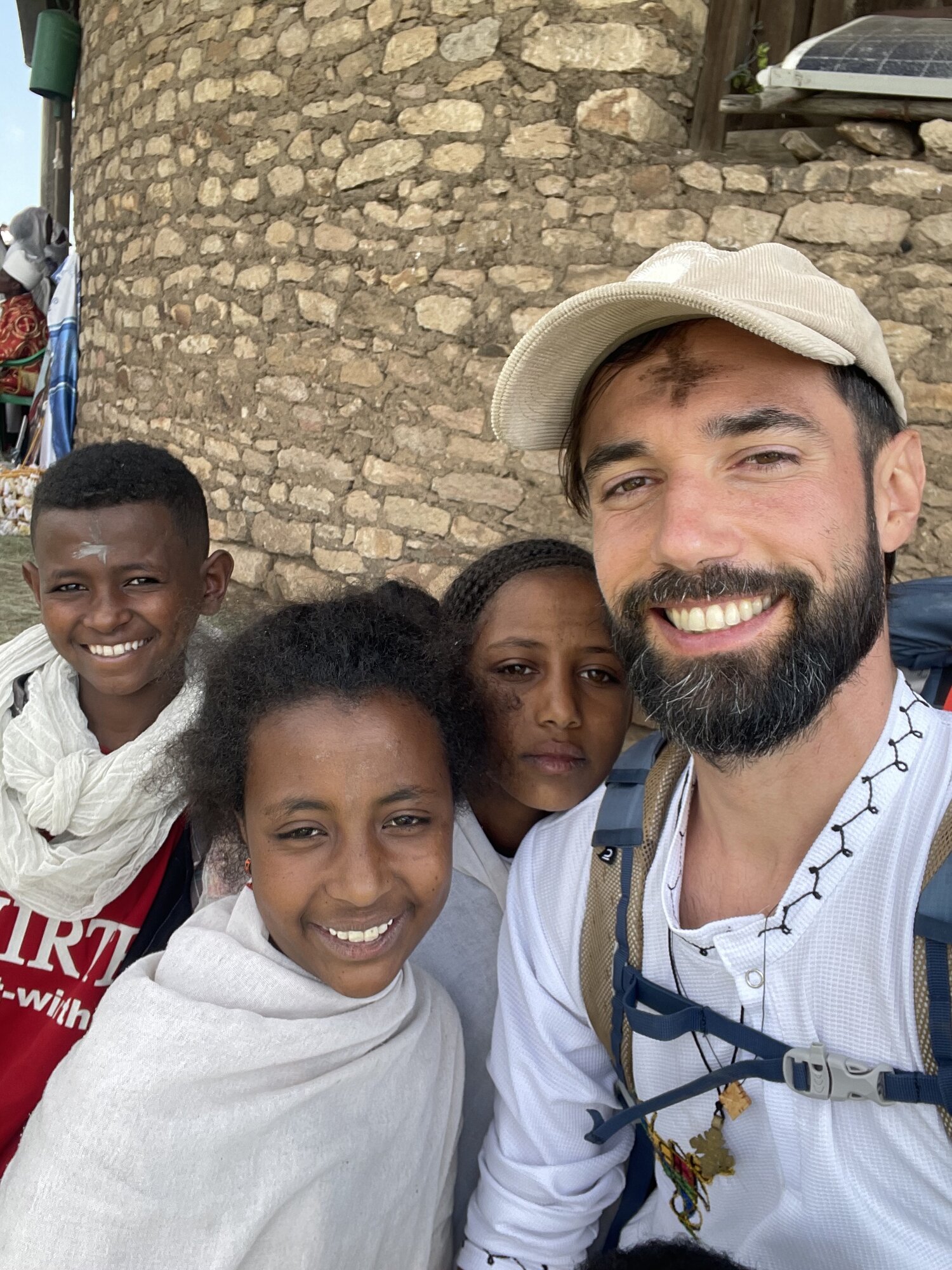 Selfie with local kids by a church wall in Lalibela